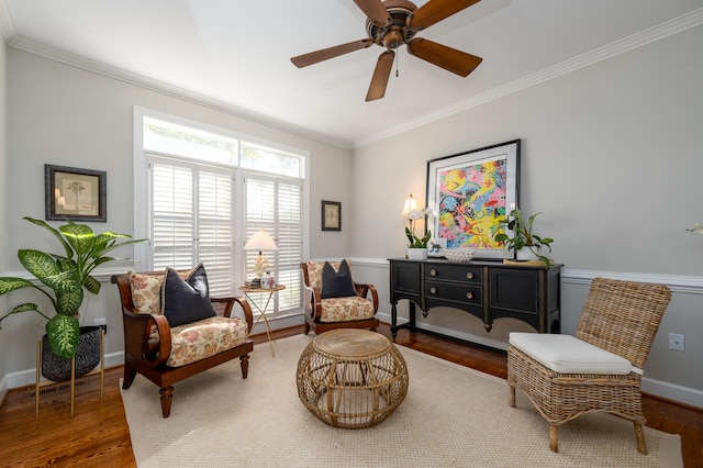 living area with crown molding and hardwood / wood-style flooring