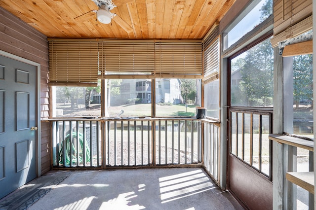 unfurnished sunroom featuring wooden ceiling and ceiling fan