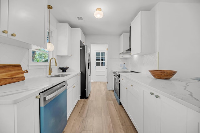 kitchen with visible vents, light wood finished floors, a sink, appliances with stainless steel finishes, and tasteful backsplash