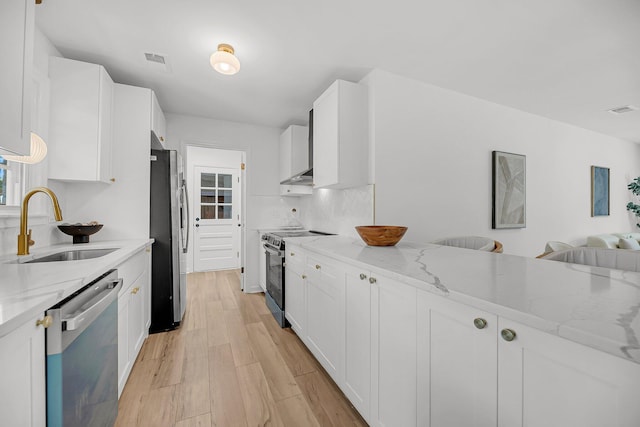 kitchen with visible vents, light wood-type flooring, a sink, stainless steel appliances, and light stone countertops