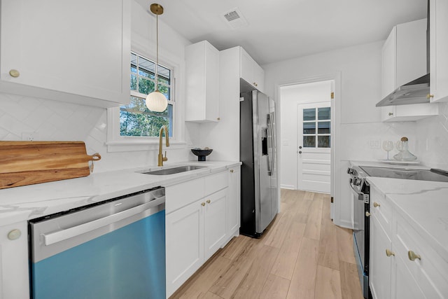 kitchen featuring tasteful backsplash, white cabinets, stainless steel appliances, and a sink