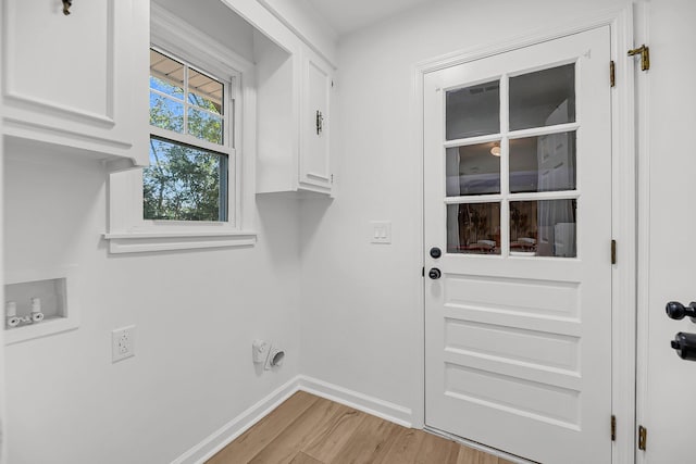 laundry room with baseboards, light wood finished floors, cabinet space, electric dryer hookup, and washer hookup