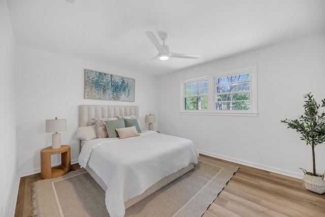 bedroom featuring ceiling fan, baseboards, and wood finished floors