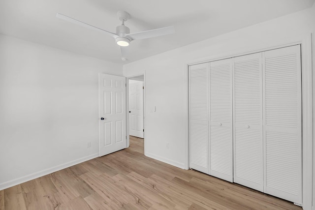 unfurnished bedroom featuring a ceiling fan, light wood-style floors, baseboards, and a closet