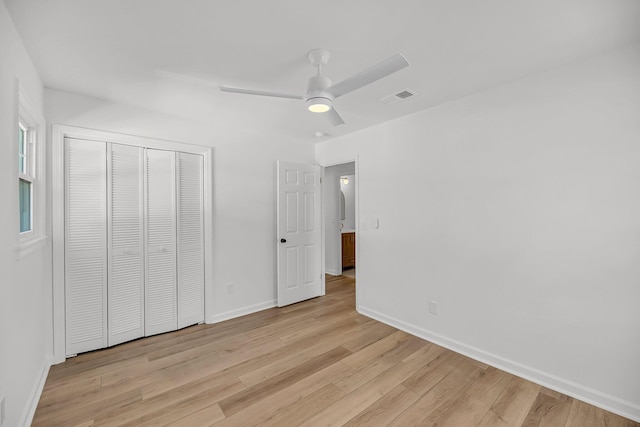 unfurnished bedroom featuring visible vents, baseboards, light wood-type flooring, a closet, and a ceiling fan