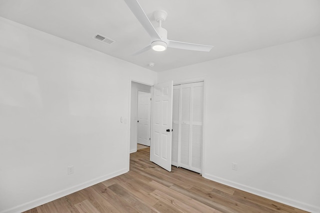 unfurnished bedroom with a closet, visible vents, baseboards, and light wood-style floors