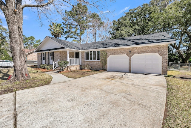 ranch-style home with brick siding, an attached garage, driveway, and fence