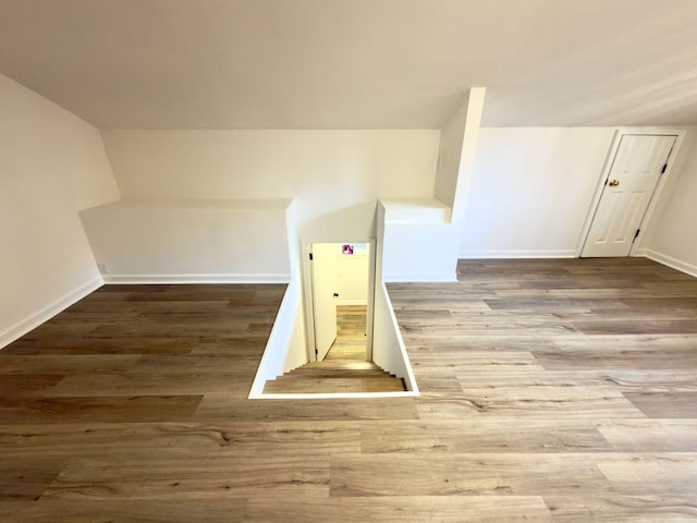 bonus room featuring baseboards and wood finished floors