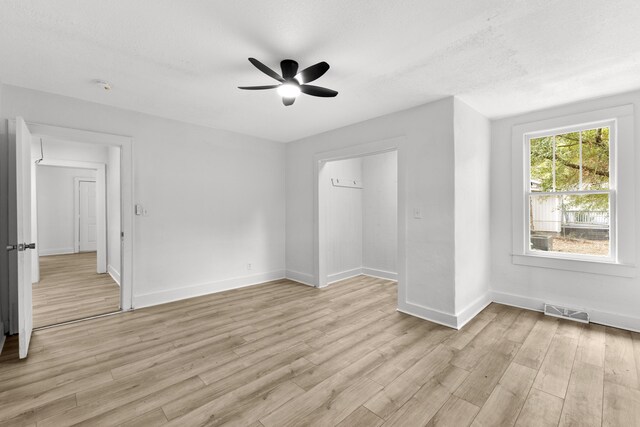 unfurnished bedroom with ceiling fan, light hardwood / wood-style floors, and a textured ceiling