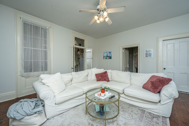 living room featuring dark wood-type flooring and ceiling fan