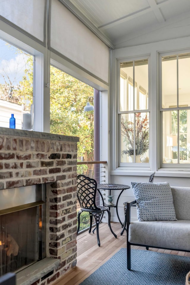 sunroom featuring a brick fireplace