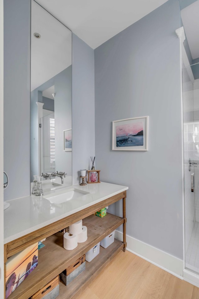 bathroom featuring walk in shower, vanity, and wood-type flooring