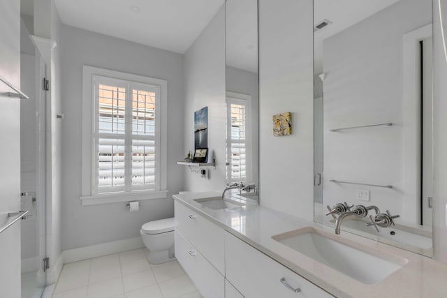 bathroom with toilet, tile patterned flooring, a shower with door, and vanity