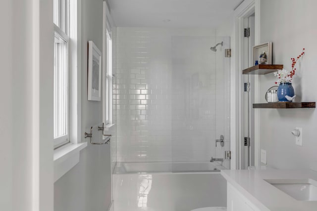 bathroom with tiled shower / bath combo and vanity