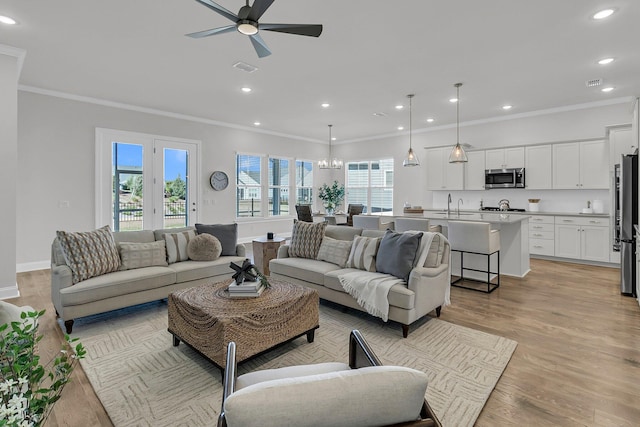 663 Marsh Cove Cir, Summerville, SC 29486 - living room with light wood-style flooring, ornamental molding, ceiling fan with notable chandelier, and recessed lighting