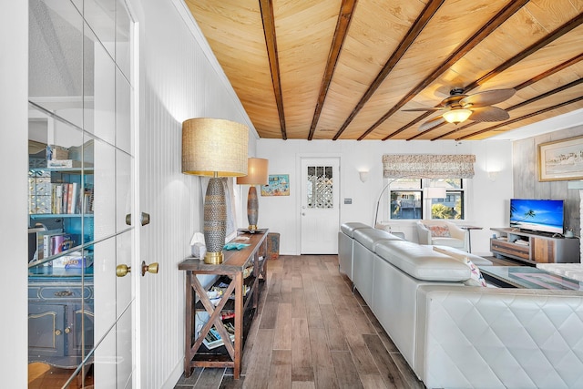 living room featuring dark wood-type flooring, ceiling fan, beam ceiling, and wooden ceiling