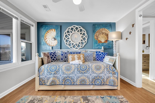 bedroom featuring hardwood / wood-style flooring, ceiling fan, and crown molding