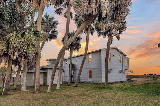 back house at dusk featuring a yard