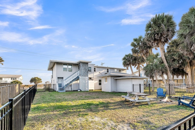 rear view of house featuring a yard