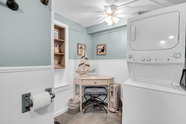 clothes washing area with stacked washer and dryer, built in shelves, and ceiling fan