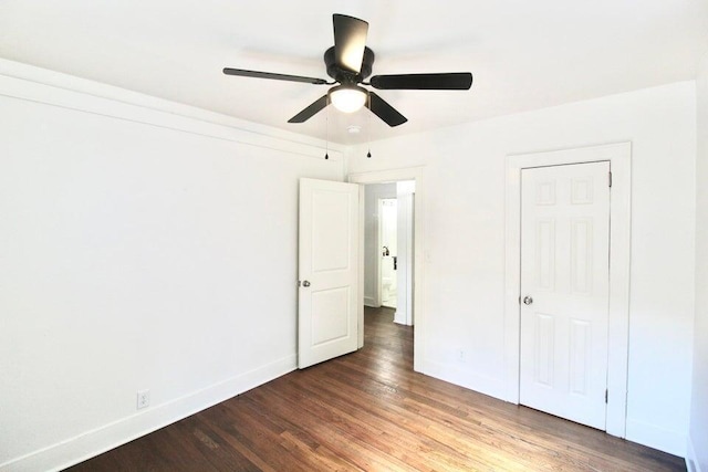 unfurnished bedroom with ceiling fan and dark hardwood / wood-style flooring