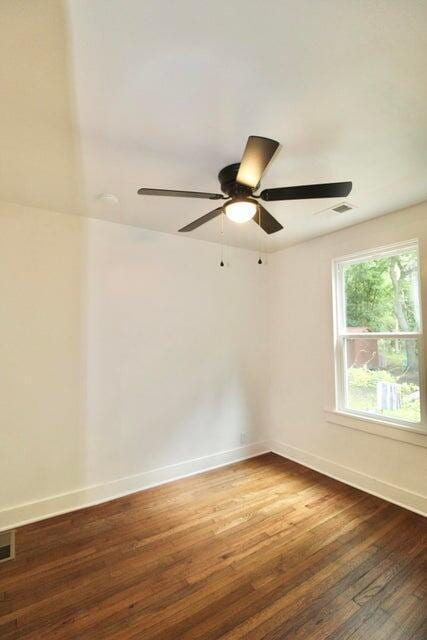 empty room featuring ceiling fan and dark wood-type flooring