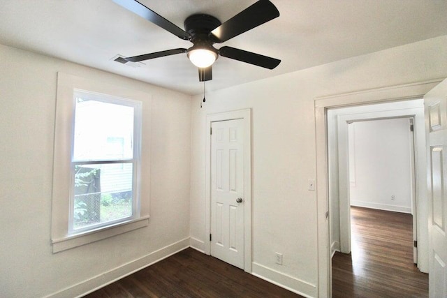 unfurnished bedroom with ceiling fan and dark hardwood / wood-style flooring