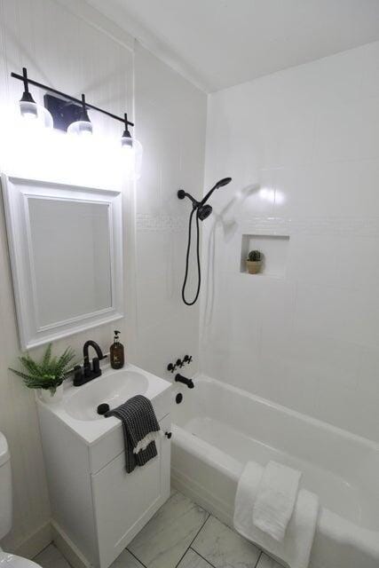 full bathroom featuring vanity, washtub / shower combination, and toilet