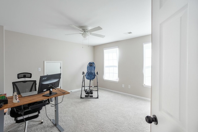 carpeted office space featuring ceiling fan