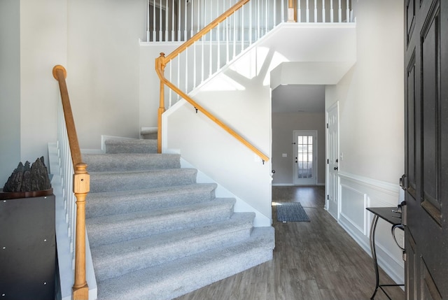 entryway featuring a towering ceiling and dark hardwood / wood-style floors