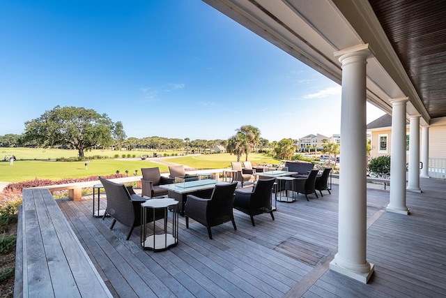 wooden deck with an outdoor fire pit, outdoor dining space, and view of golf course