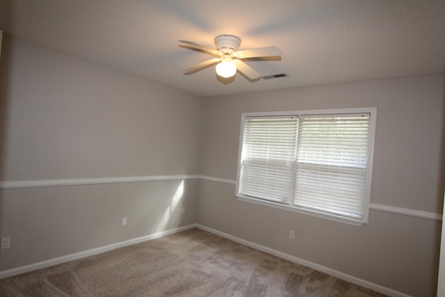 carpeted empty room featuring a textured ceiling and ceiling fan