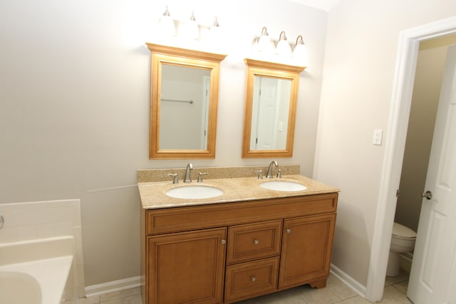 bathroom featuring toilet, a tub, vanity, and tile patterned flooring