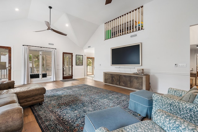 living room with wood-type flooring, high vaulted ceiling, and ceiling fan