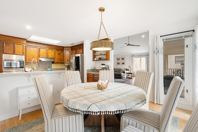 dining room with sink and light wood-type flooring