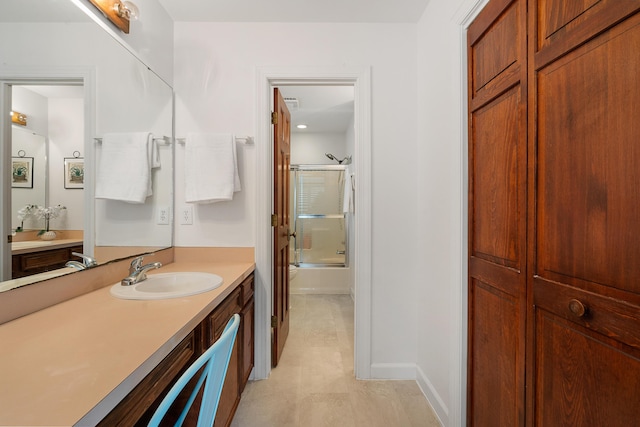 full bathroom featuring vanity, bath / shower combo with glass door, and toilet