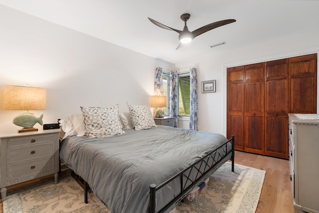 bedroom featuring ceiling fan, light hardwood / wood-style floors, and a closet