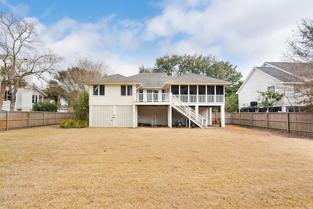 back of property featuring a sunroom and a lawn