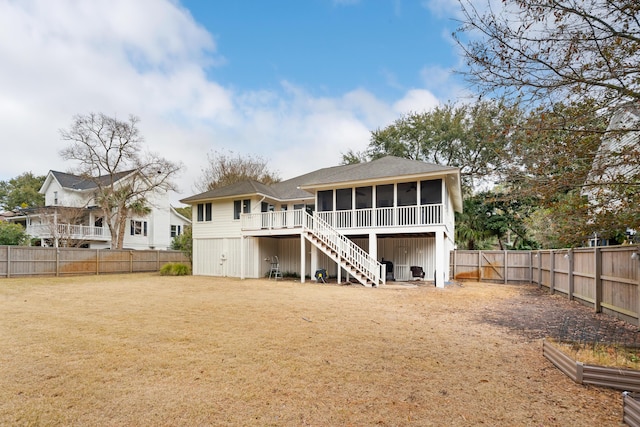 rear view of house featuring a sunroom and a yard