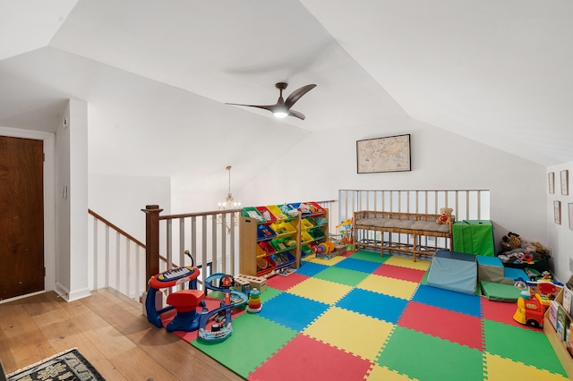 rec room featuring ceiling fan with notable chandelier, lofted ceiling, and hardwood / wood-style floors