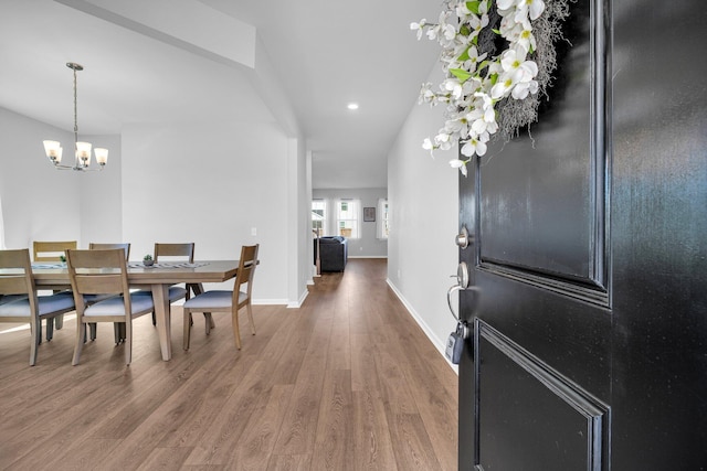 entryway with dark hardwood / wood-style flooring and a notable chandelier