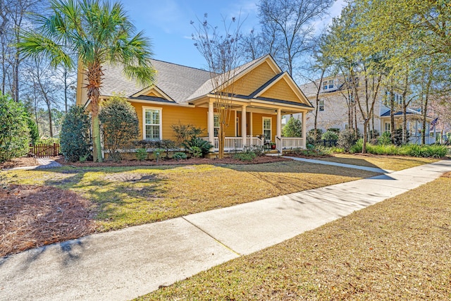 view of front facade with covered porch and a front yard