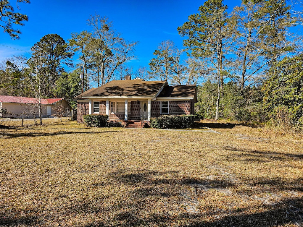 ranch-style home with a porch and a front lawn