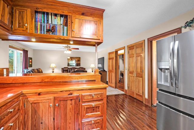 kitchen with ceiling fan, washer / dryer, stainless steel refrigerator with ice dispenser, a textured ceiling, and dark hardwood / wood-style flooring