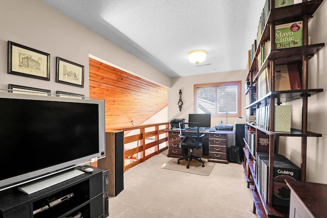 carpeted home office featuring a textured ceiling