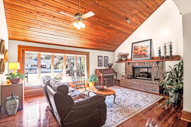 living room featuring wood-type flooring, a brick fireplace, vaulted ceiling, ceiling fan, and wooden ceiling