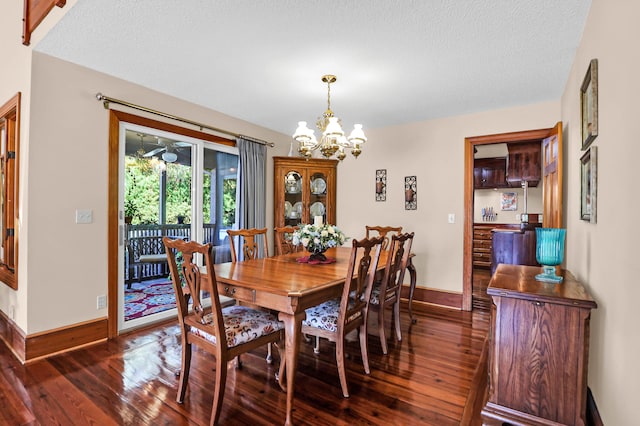 dining room with a textured ceiling, dark wood-type flooring, and a chandelier