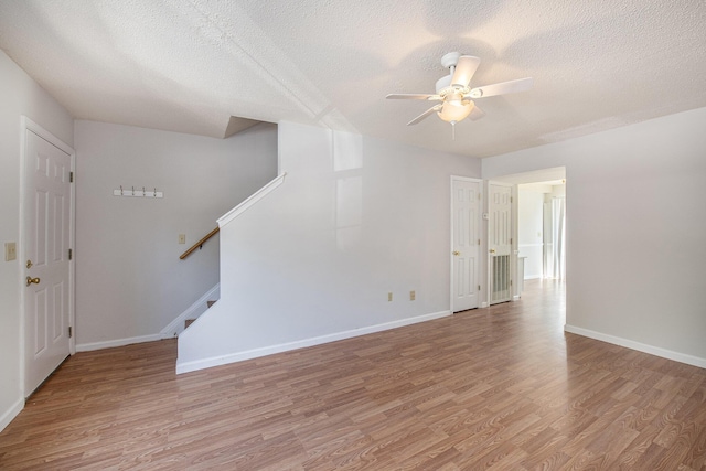 111 Elmwood Ave Unit A, Ladson, SC 29456 - empty room featuring light wood-type flooring, a ceiling fan, a textured ceiling, stairs, and baseboards