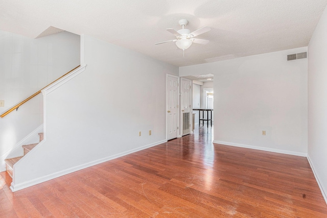 111 Elmwood Ave Unit A, Ladson, SC 29456 - empty room featuring ceiling fan, wood finished floors, stairway, baseboards, and a textured ceiling