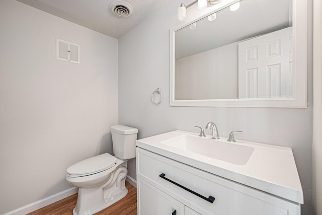 111 Elmwood Ave Unit A, Ladson, SC 29456 - half bath with wood finished floors, toilet, baseboards, vanity, and a textured ceiling
